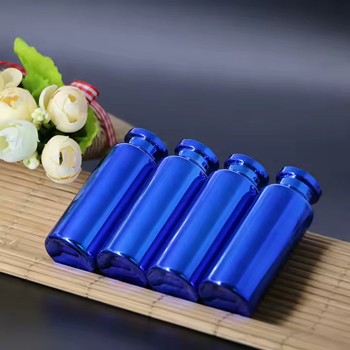 Four opaque blue vials resting on a bamboo mat, representing the light-protective packaging used to store freeze-dried GHK-Cu peptides before reconstitution with a solvent.