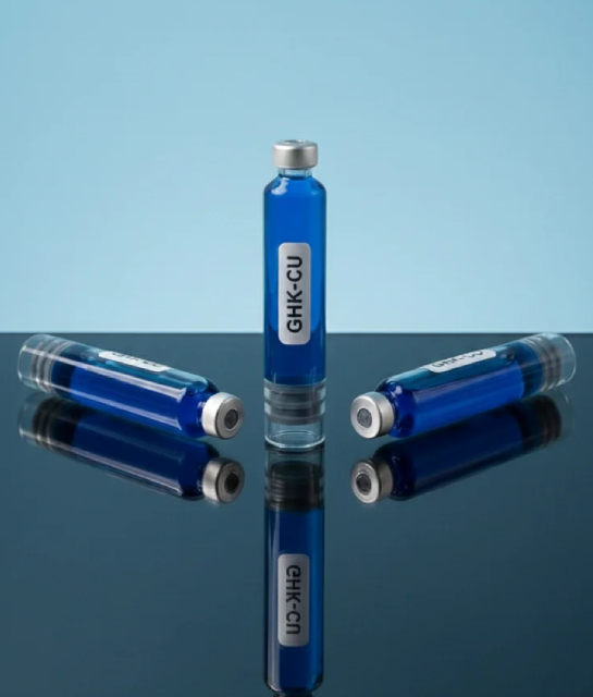Three vials of bright blue GHK-CU solution on a reflective surface, representing the copper tripeptides researched for hair follicle biology and scalp health.