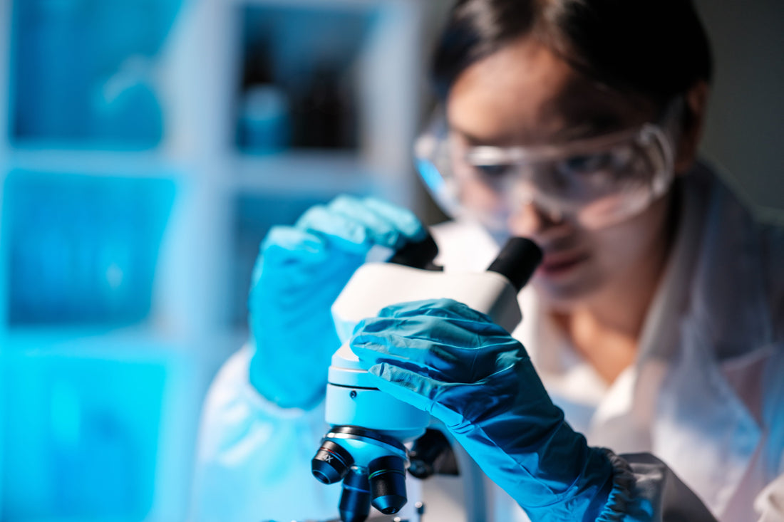 A researcher analysing samples under a microscope, showing the clinical study of PT-141 peptide mechanisms.